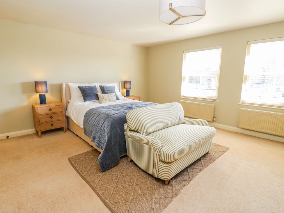 A bedroom with a bed and armchair at 27 West Green
