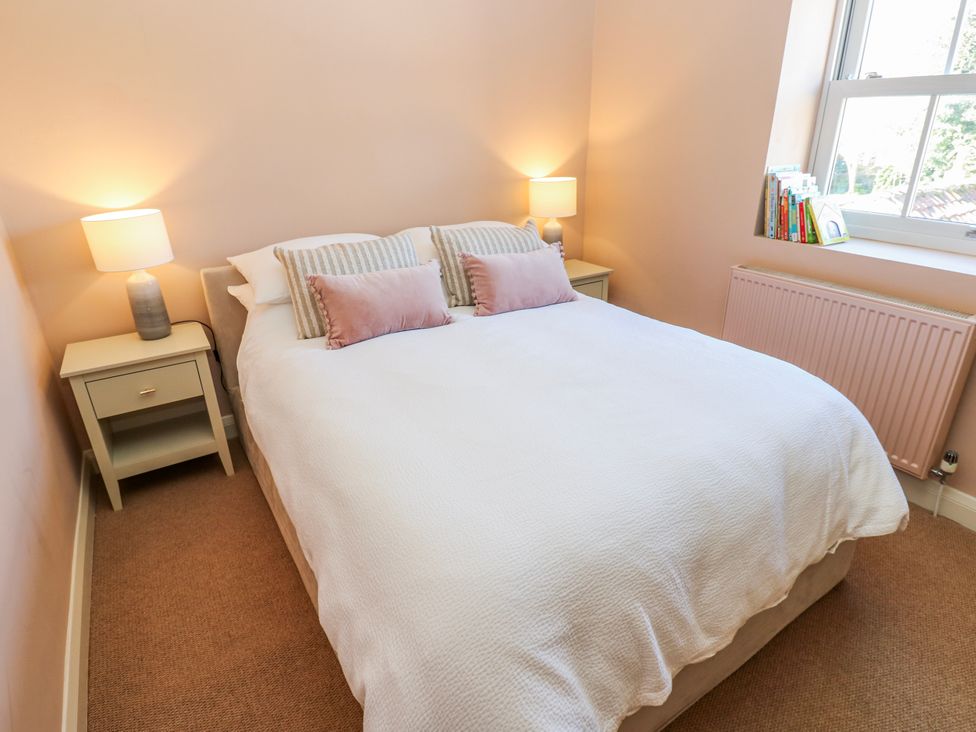 A bedroom with a bed and bedside tables at 27 West Green