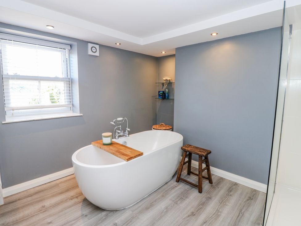 A bathroom with a bathtub and shelf at 27 West Green