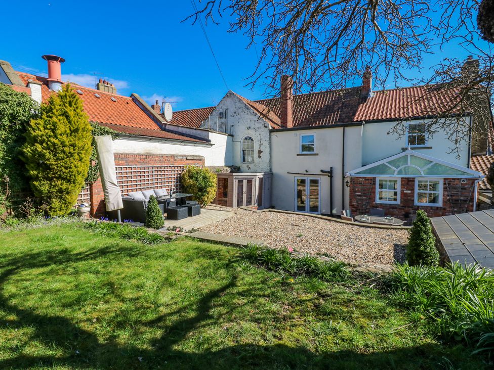 A garden with outdoor furniture and a house behind at 27 West Green