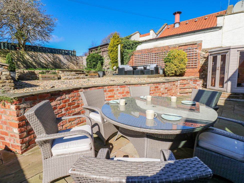 A garden with a table and chairs at 27 West Green