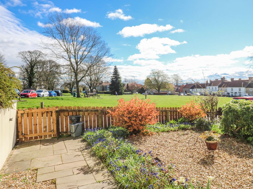 A garden with a flower bed and view of a park at 27 West Green