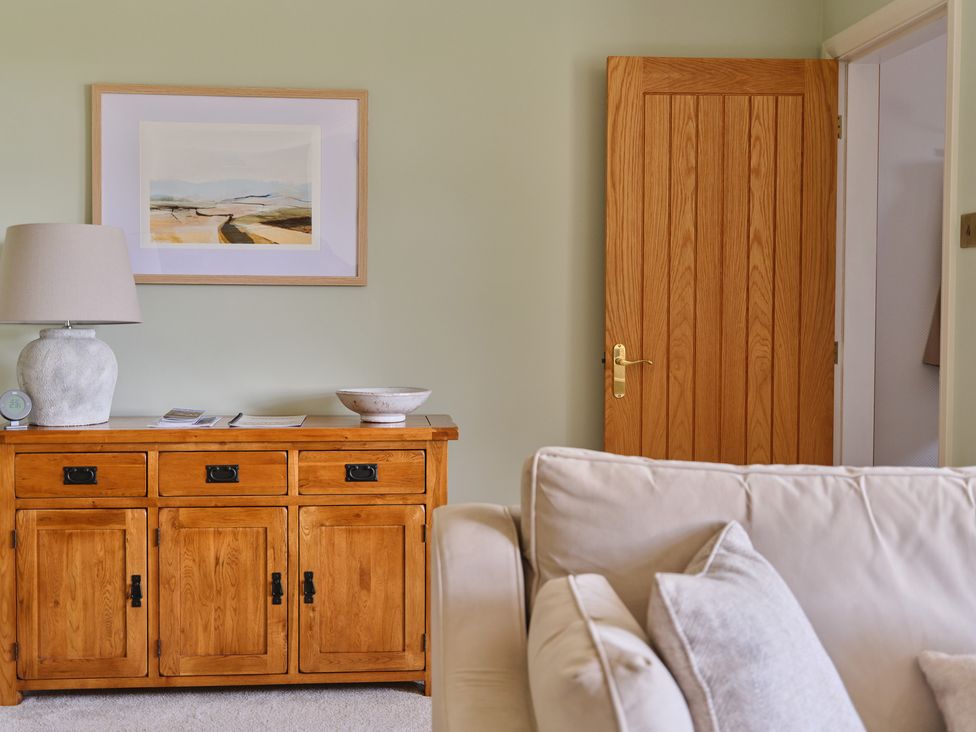 A living room with a cabinet and lamp at 27 West Green in Heighington