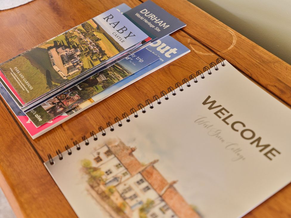 A wooden table with brochures and a welcome notebook at 27 West Green in Heighington