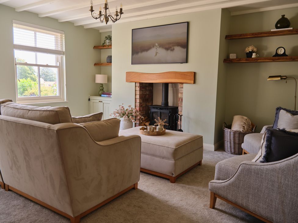 A living room with sofas and a fireplace at 27 West Green in Heighington