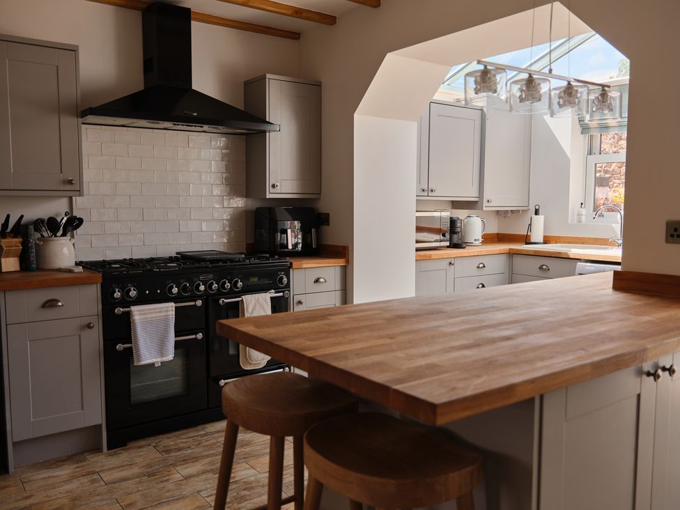 A kitchen with an island and appliances at 27 West Green in Heighington
