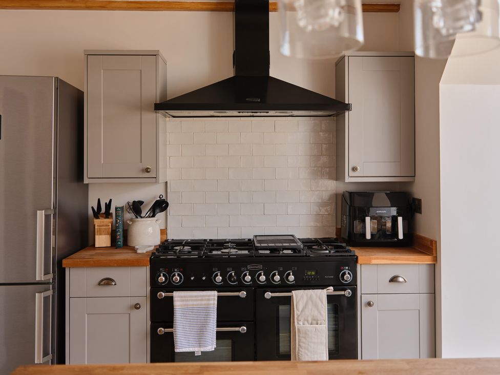 A kitchen with a stove and refrigerator at 27 West Green Heighington