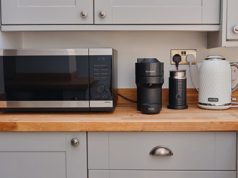 Kitchen countertop with a microwave, coffee machine, milk frother and kettle at 27 West Green Heighington