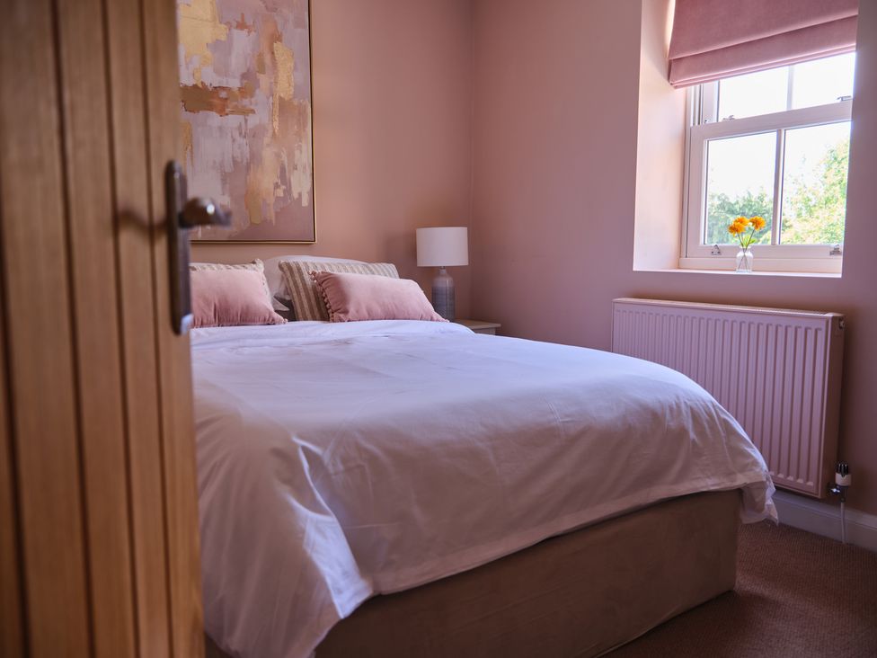 A bedroom with a bed and lamp at 27 West Green in Heighington
