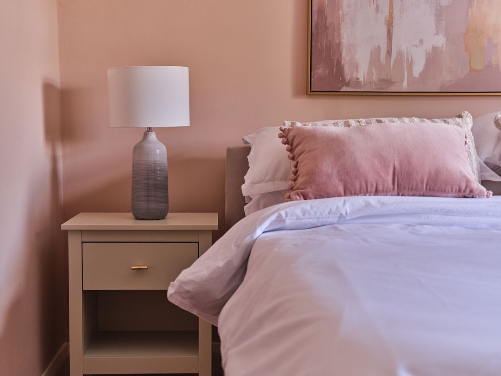 A bedroom with a lamp and nightstand beside a bed at 27 West Green in Heighington