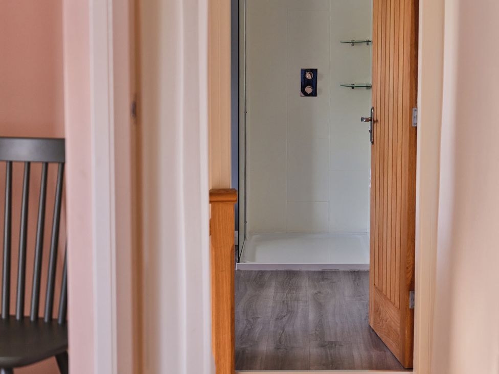 A bathroom with a shower and door at 27 West Green in Heighington