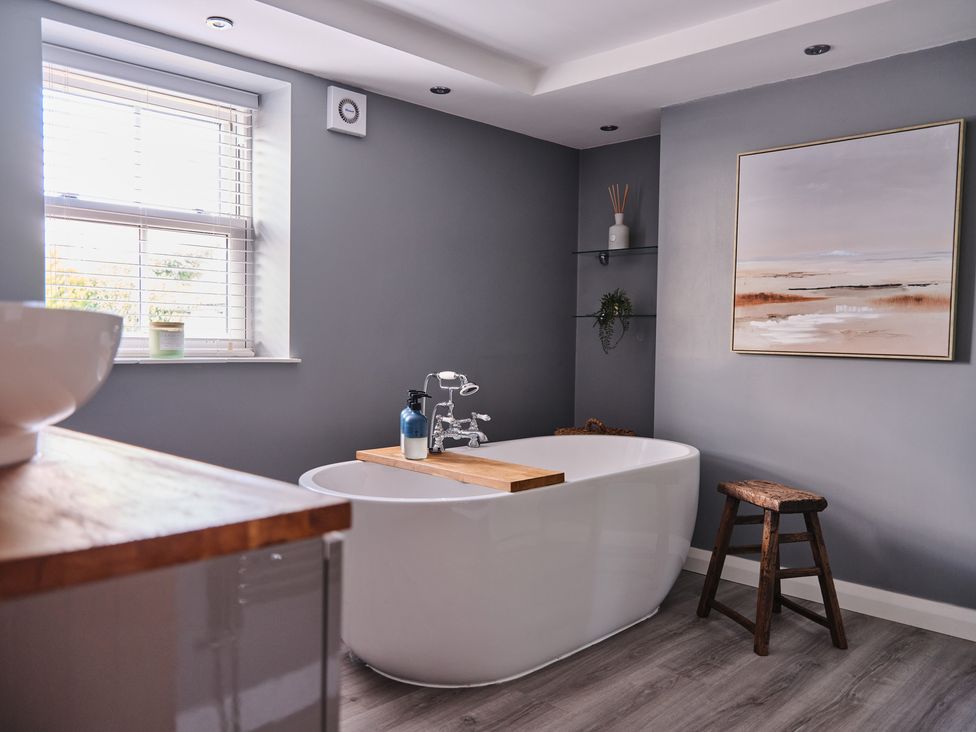 A bathroom with a bathtub and window at 27 West Green Heighington