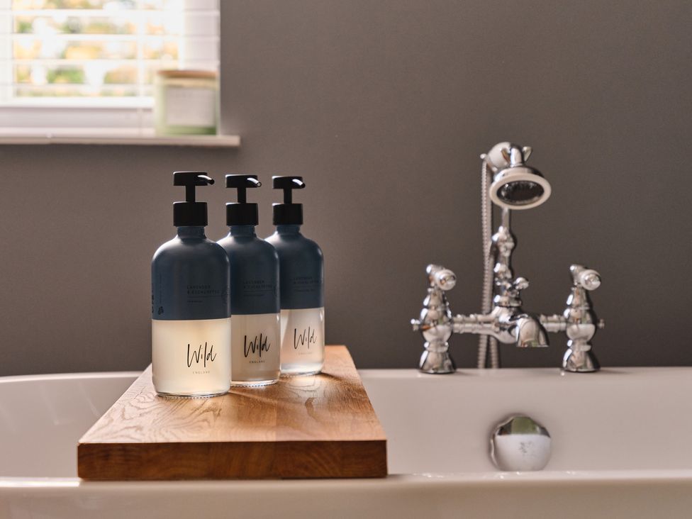 A bathroom with soap dispensers on a wooden shelf at 27 West Green in Heighington