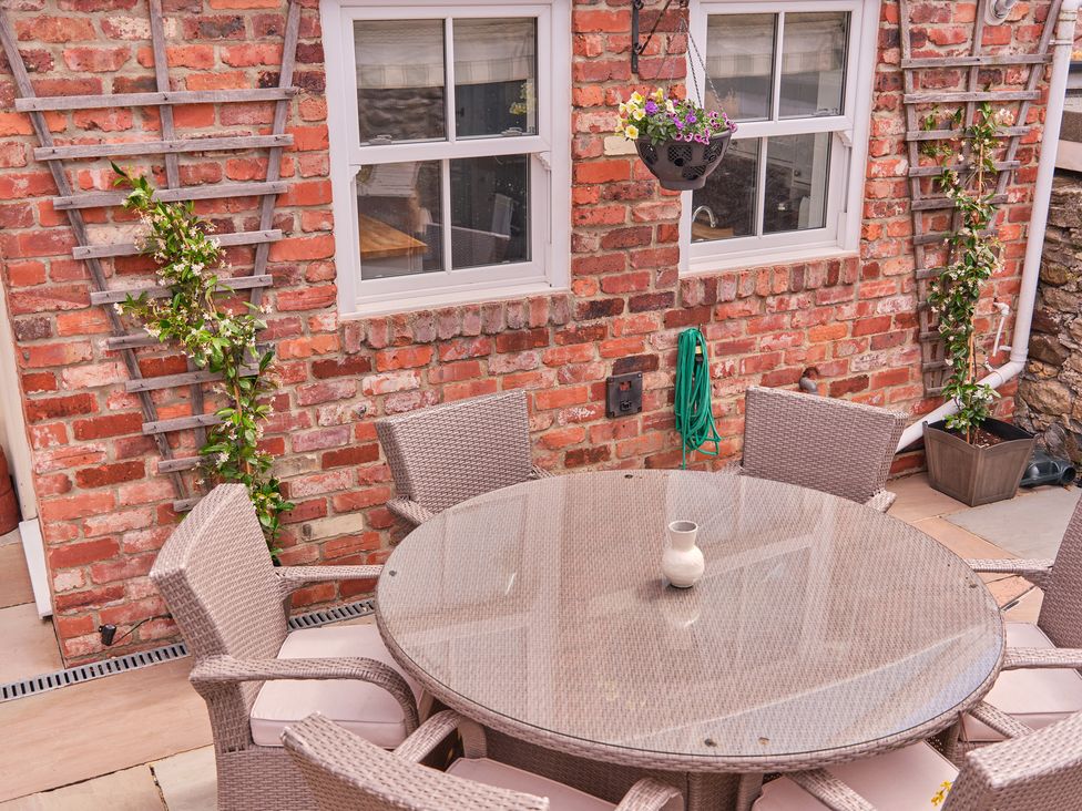 An outdoor dining area with a table and chairs at 27 West Green in Heighington