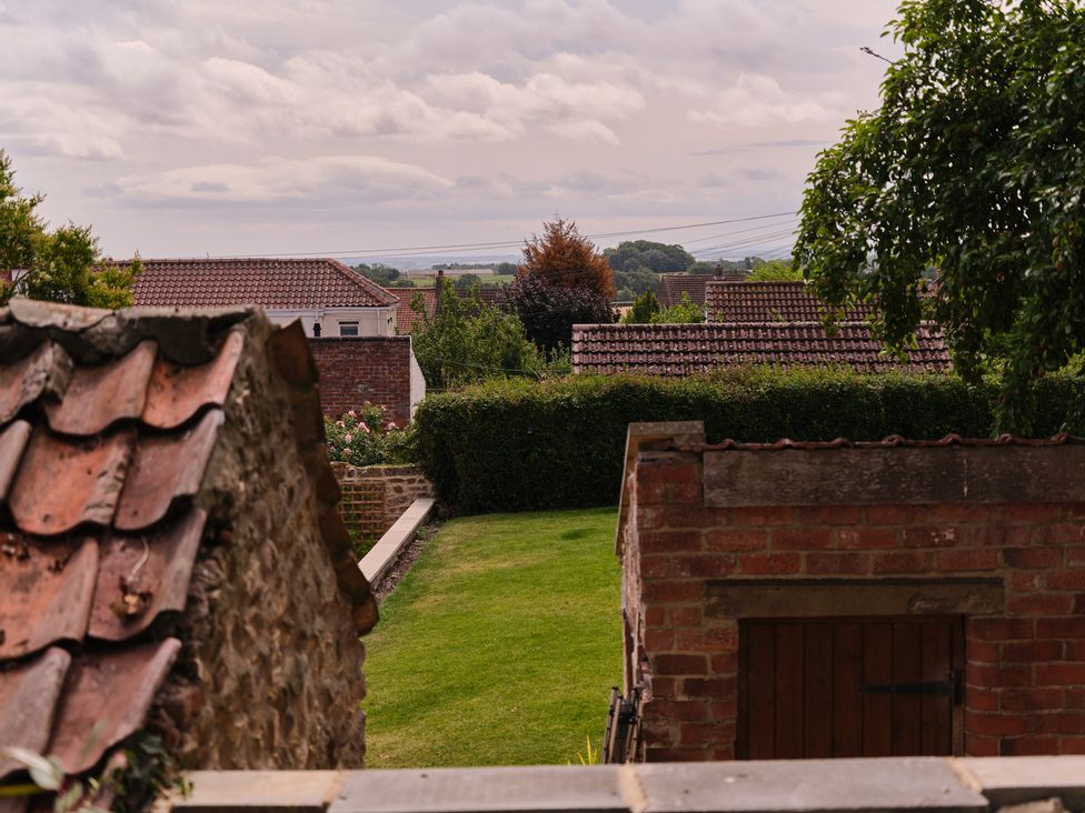 A garden view with grass and a shed at 27 West Green in Heighington