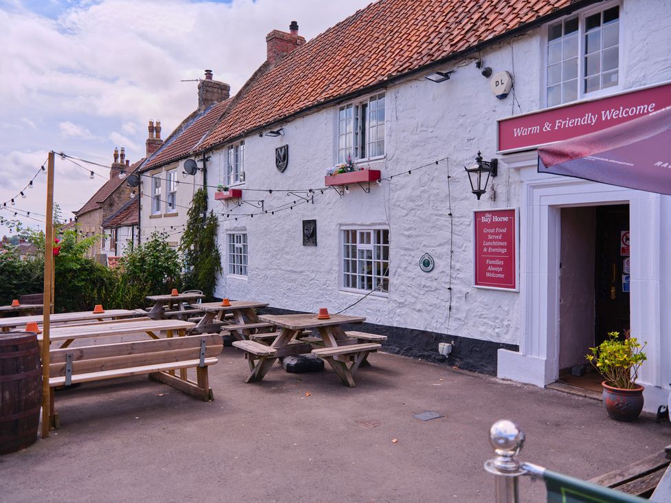 An outdoor area with tables and benches at 27 West Green in Heighington