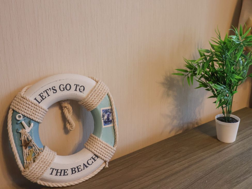 A lifebuoy and a potted plant on a table at Gorse Hill 211 Exmouth