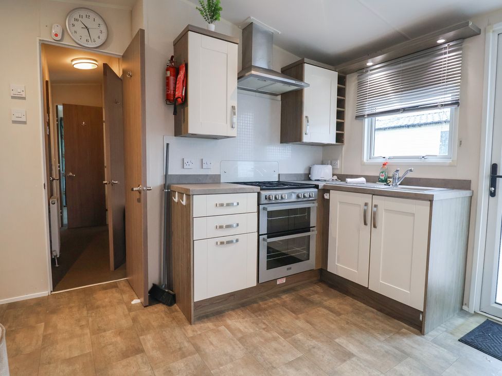 A kitchen with cabinets and appliances at Gorse Hill 211 Exmouth