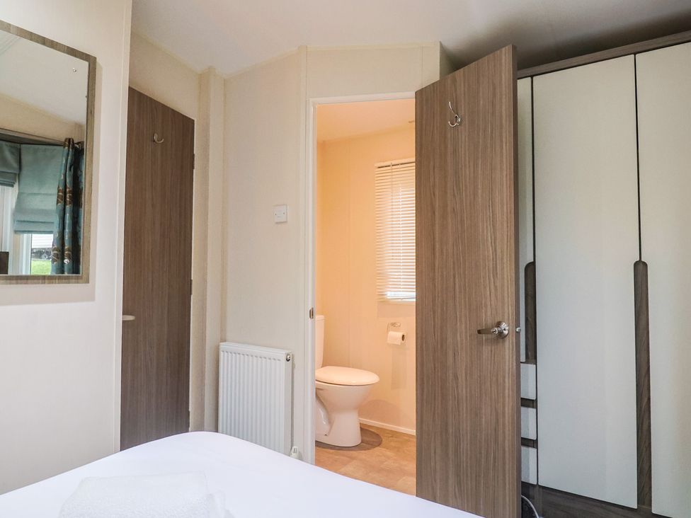 A bathroom with a toilet visible from another room at Gorse Hill 211 Exmouth