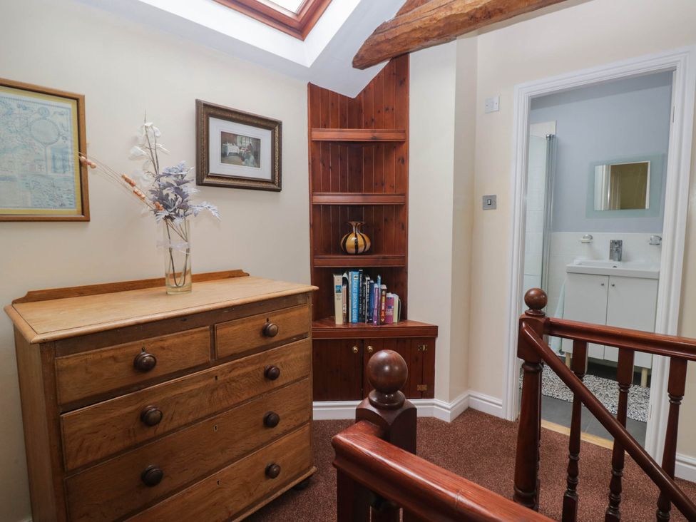 A hallway with a dresser and bookshelf at The Spinney near Milnthorpe