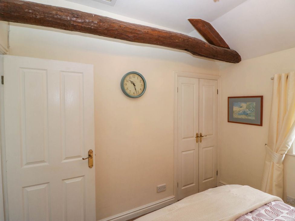 A bedroom with a clock and doors in The Spinney near Milnthorpe