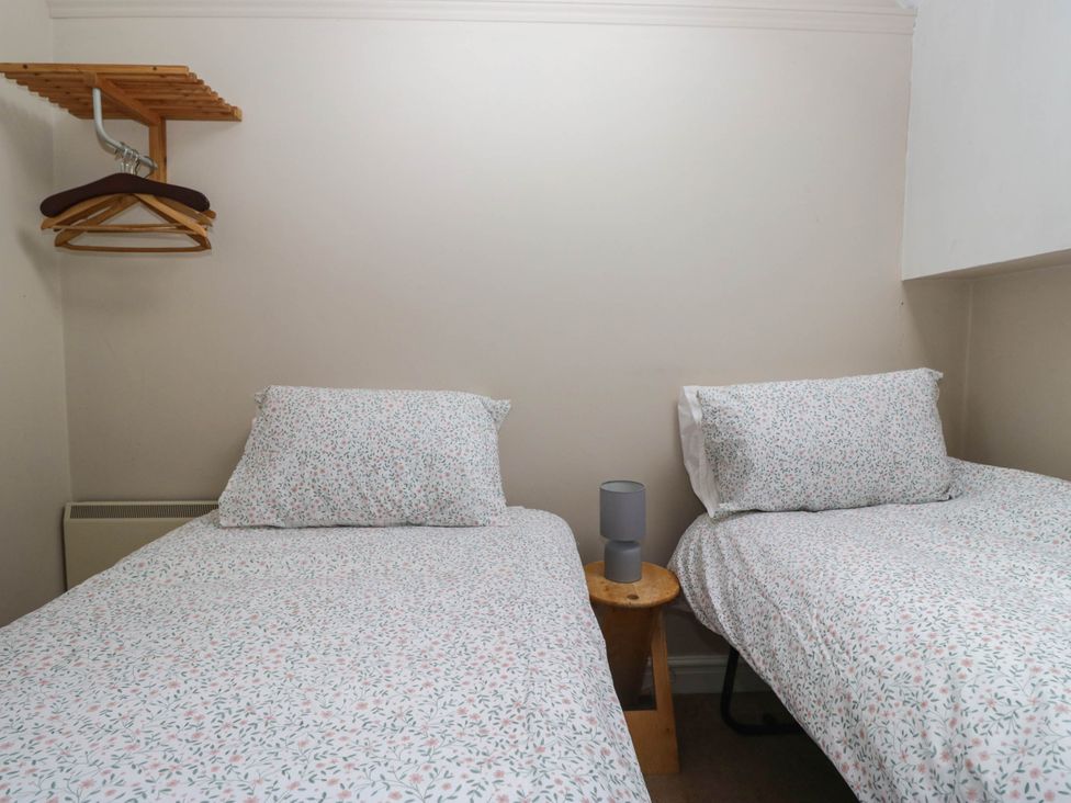 A bedroom with two beds and a lamp at The Spinney near Milnthorpe