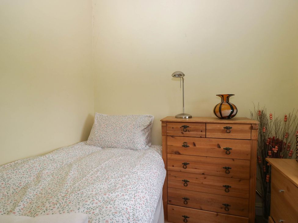 A bedroom with a bed and furniture at The Spinney near Milnthorpe