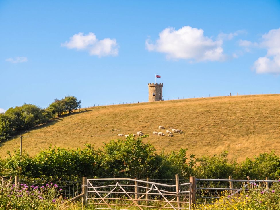 A landscape featuring a tower on a hill with sheep grazing at The Spinney near Milnthorpe