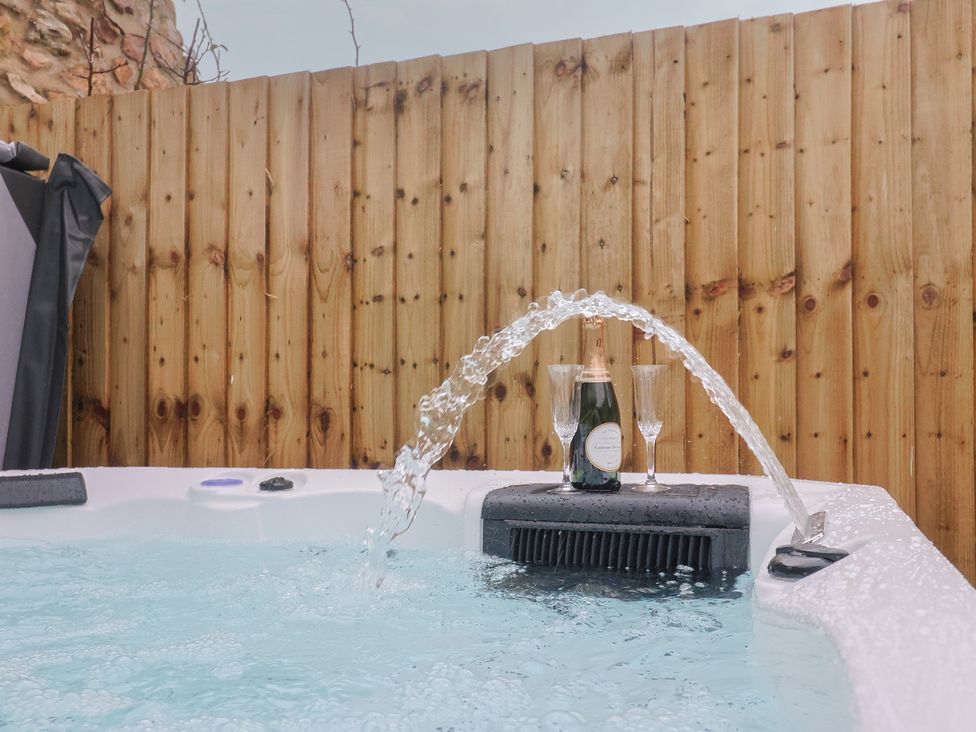 A hot tub with champagne and glasses at Rose Cottage in Wellington