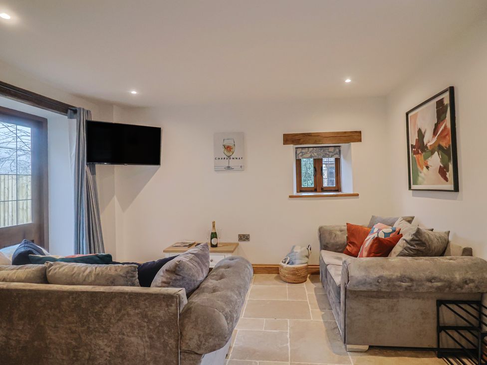 A snug with a sofa and television at Rose Cottage in Wellington