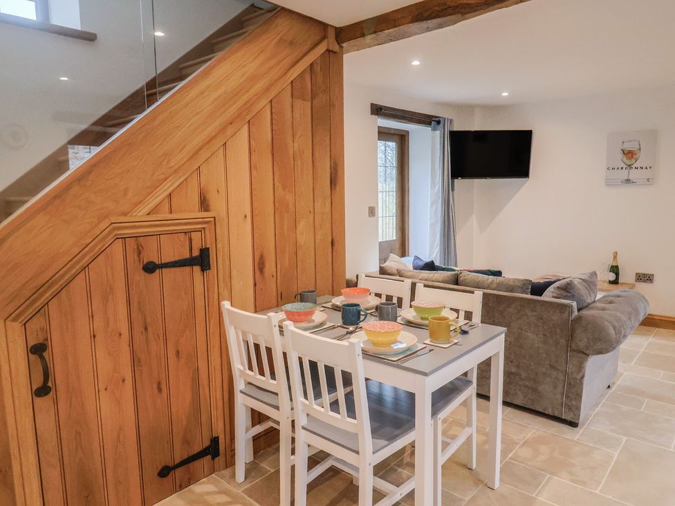 A living room with a dining table and sofa at Rose Cottage in Wellington