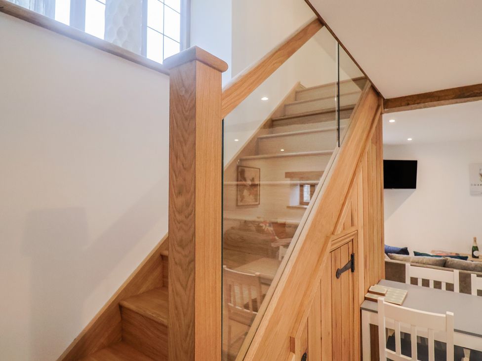 A staircase with wooden stairs and glass panel at Rose Cottage Wellington
