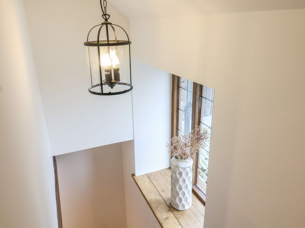 A hallway with a lamp and a window at Rose Cottage in Wellington
