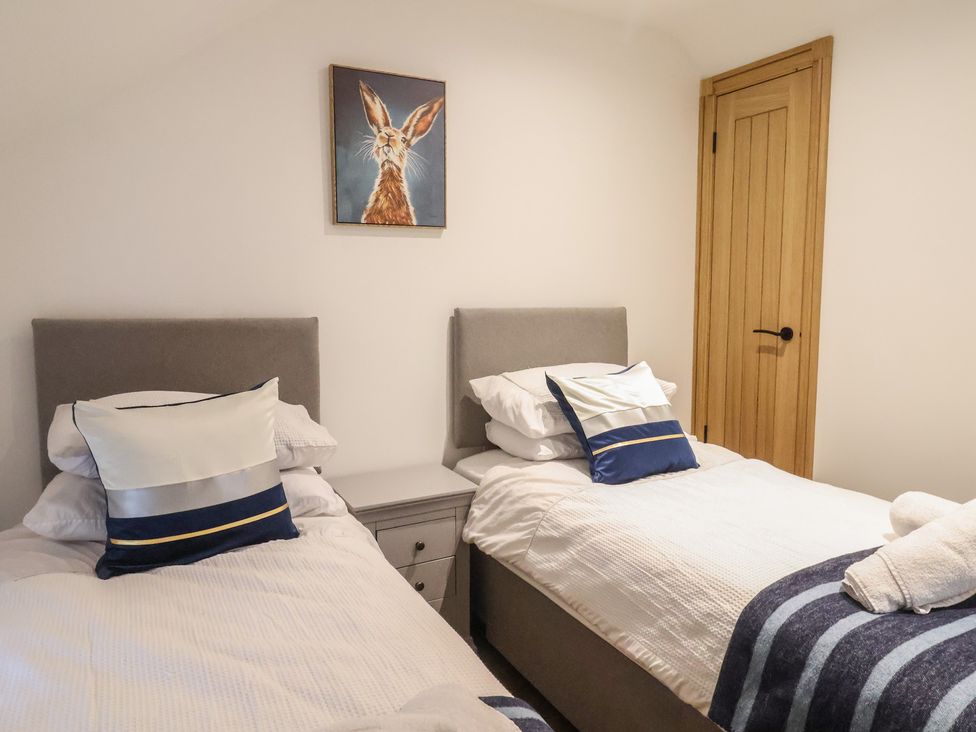 A bedroom with two beds and a painting at Rose Cottage in Wellington