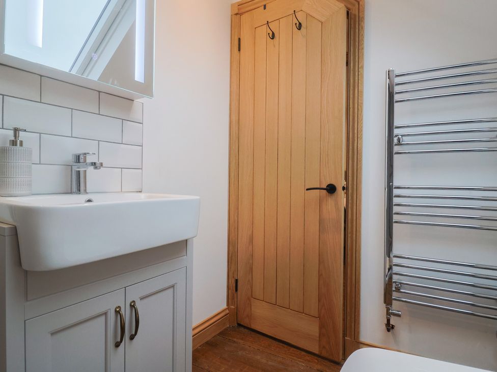 A bathroom with a sink and mirror at Rose Cottage in Wellington
