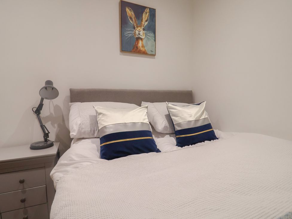 A bedroom with a bed and lamp at Rose Cottage Wellington