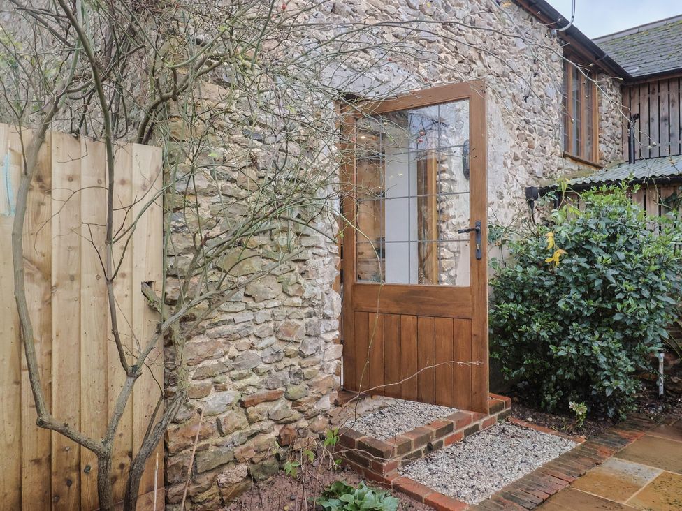 An entrance door with stone wall and gravel pathway at Rose Cottage Wellington