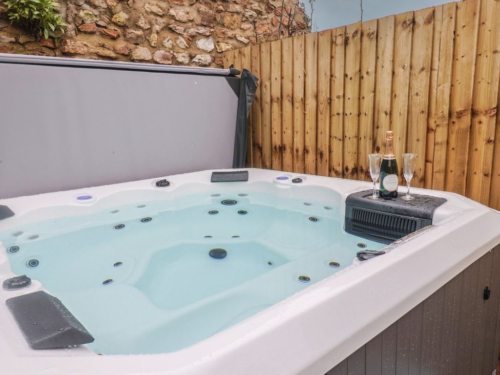 A hot tub with champagne and glasses at Rose Cottage in Wellington