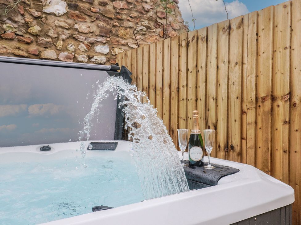 A hot tub with champagne and flutes at Rose Cottage in Wellington