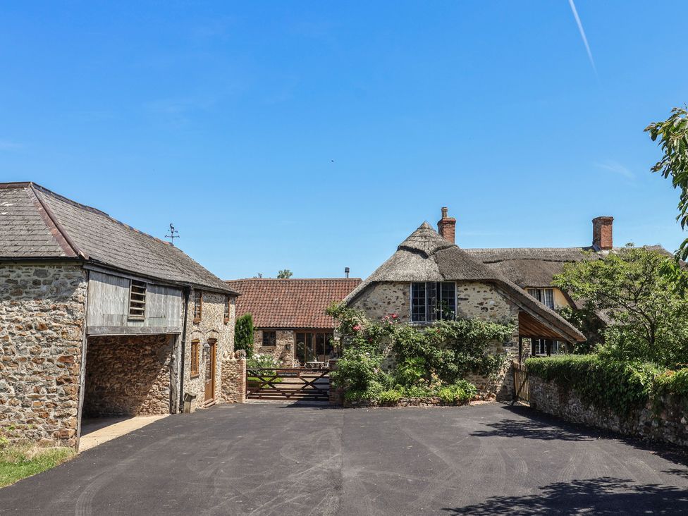 A view of a barn and thatched roof house at Rose Cottage in Wellington
