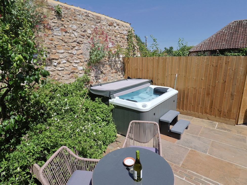 An outdoor space with a hot tub and seating area at Rose Cottage in Wellington