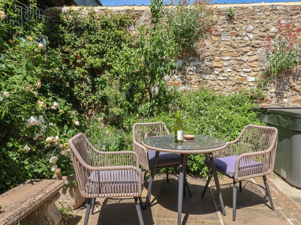 A garden with a table and chairs at Rose Cottage in Wellington