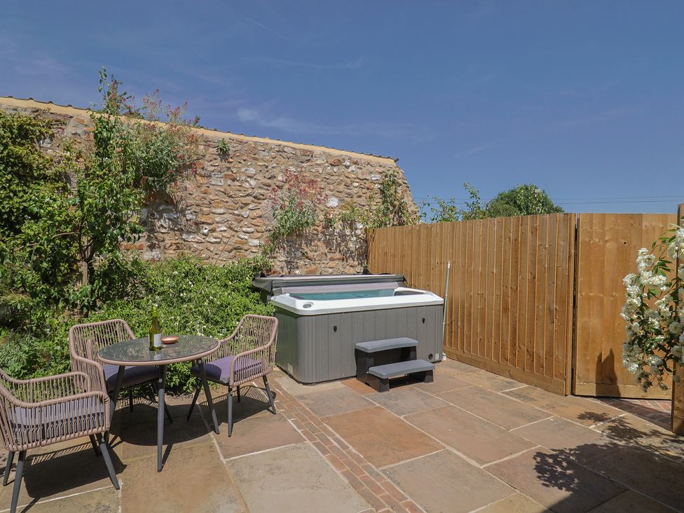 A garden with a hot tub and seating area at Rose Cottage Wellington