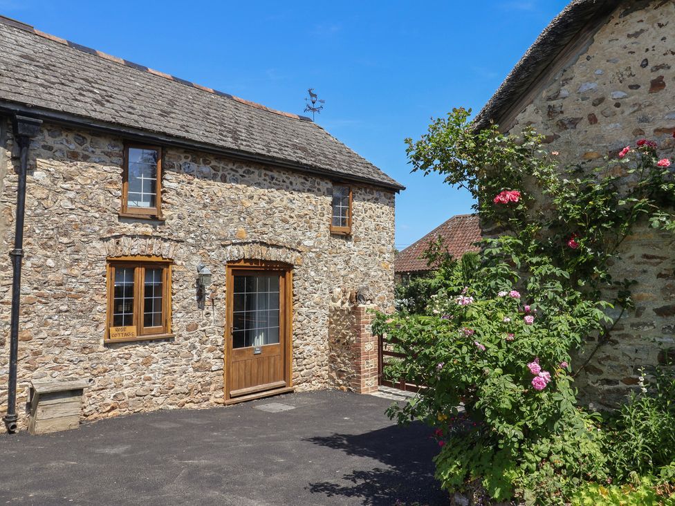 An outdoor view of a stone cottage with a wooden door at Rose Cottage in Wellington