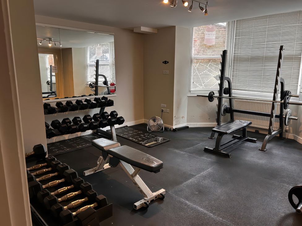 A gym with dumbbells and a weight bench at Ground Floor 1 bed in Scarborough