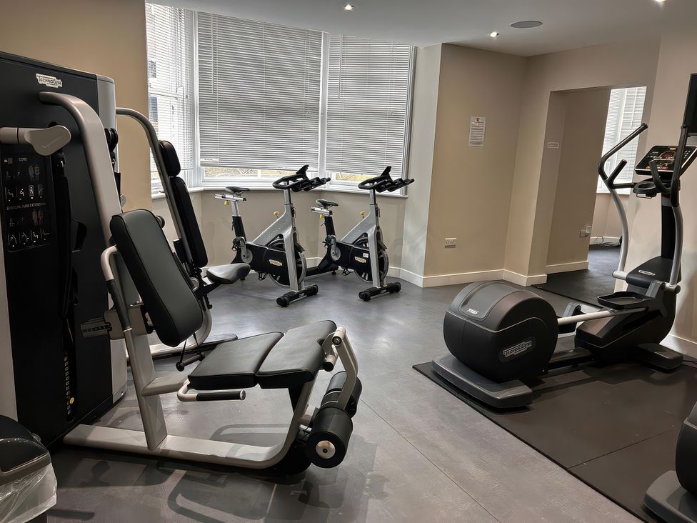 A gym with exercise equipment and large windows at Ground Floor 1 bed in Scarborough