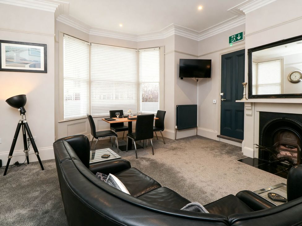 A living room with a sofa and dining table at Craven Suite in Scarborough
