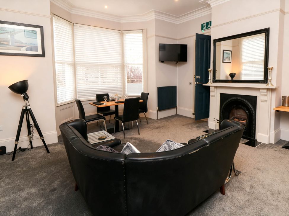 A living room with a couch and dining table at Craven Suite in Scarborough