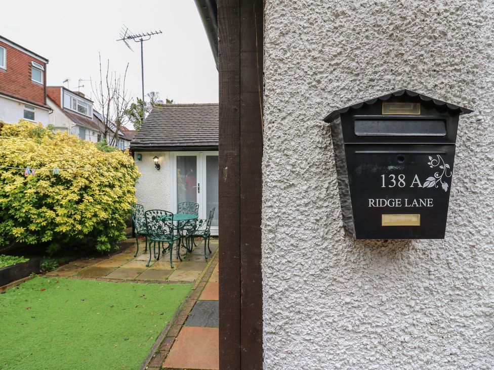 A garden with a mailbox and seating area at The Enchanted House in Watford