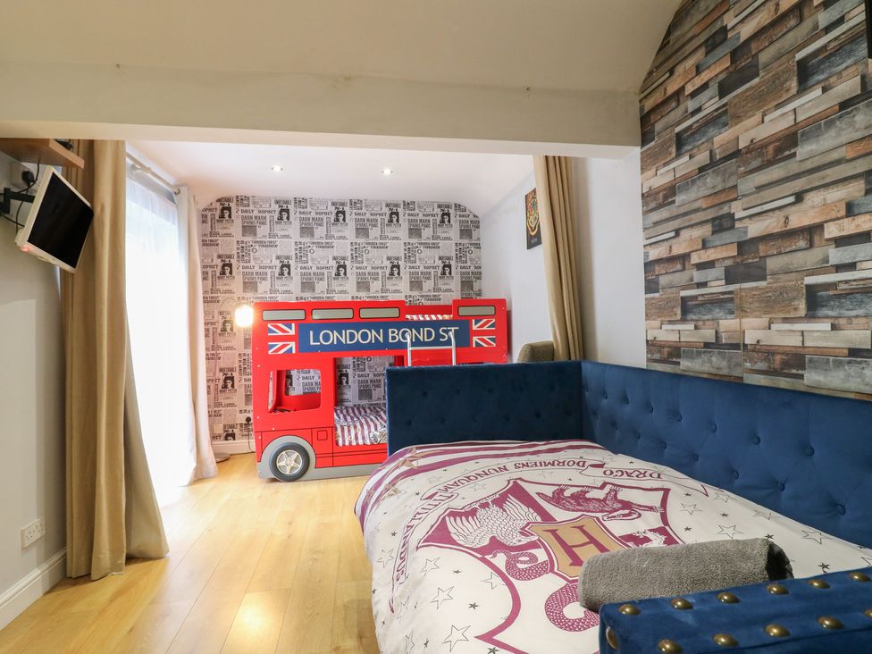 A bedroom with a bunk bed and blue sofa at The Enchanted House in Watford